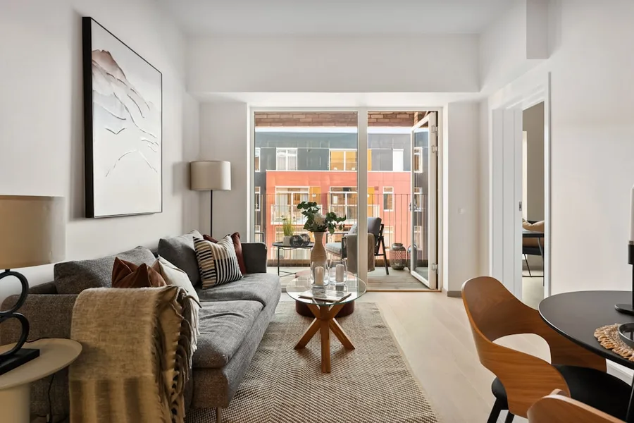 Furnished apartment living room with natural light and balcony access